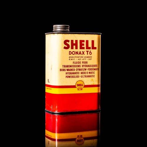 Vintage Shell oil cans with red and yellow branding from the 1900-1920 old logo Vintage Shell oil cans from 1900-19255, featuring the old logo. The photo showcases an antique tin red with yellow accents, displaying the historic Shell emblem. Shot in a studio against a solid black background