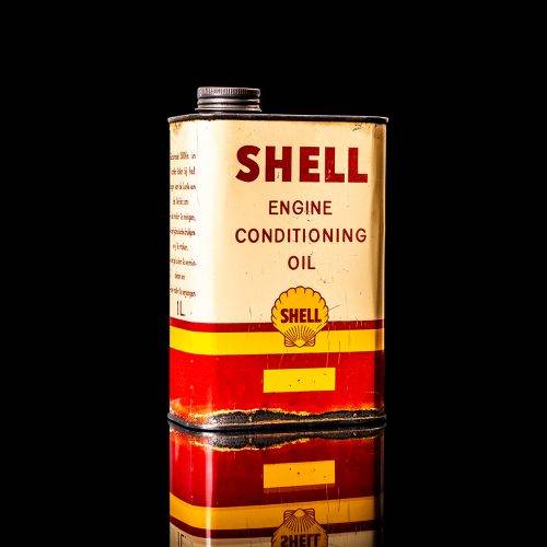Vintage Shell oil cans with red and yellow branding from the 1900-1920 old logo Vintage Shell oil cans from 1900-19255, featuring the old logo. The photo showcases an antique tin red with yellow accents, displaying the historic Shell emblem. Shot in a studio against a solid black background