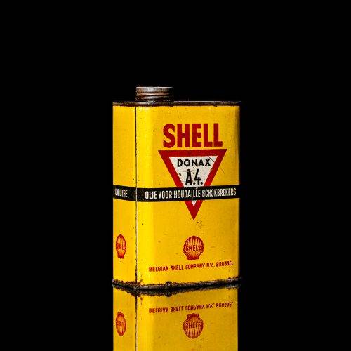 Rare and unique vintage mini Shell oil can from 1900–1950 with red and yellow accents, featuring the classic Shell logo. This small antique tin is displayed in a studio setting against a solid black background." lubricant,cleaner, outboard, motor oil, sealant, valve lubricant, two cycle, glass cleaner oil, shell cans
