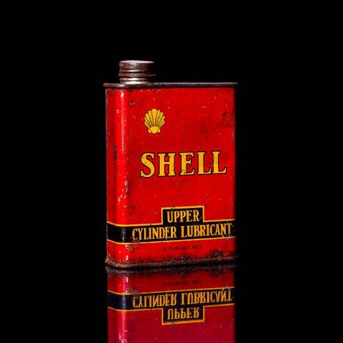 Rare and unique vintage mini Shell oil can from 1900–1950 with red and yellow accents, featuring the classic Shell logo. This small antique tin is displayed in a studio setting against a solid black background." lubricant,cleaner, outboard, motor oil, sealant, valve lubricant, two cycle, glass cleaner oil, shell cans
