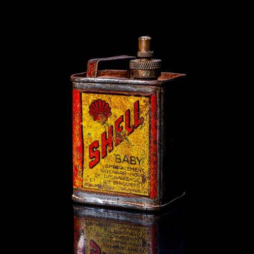 Vintage Shell oil cans with red and yellow branding from the 1900-1920 old logo Vintage Shell oil cans from 1900-19255, featuring the old logo. The photo showcases an antique tin red with yellow accents, displaying the historic Shell emblem. Shot in a studio against a solid black background