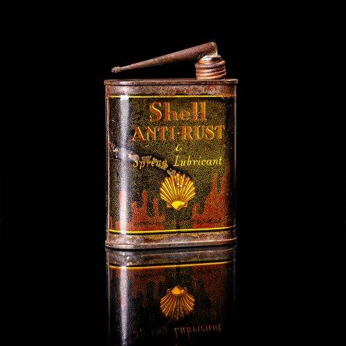 Vintage Shell oil cans with red and yellow branding from the 1900-1920 old logo Vintage Shell oil cans from 1900-19255, featuring the old logo. The photo showcases an antique tin red with yellow accents, displaying the historic Shell emblem. Shot in a studio against a solid black background