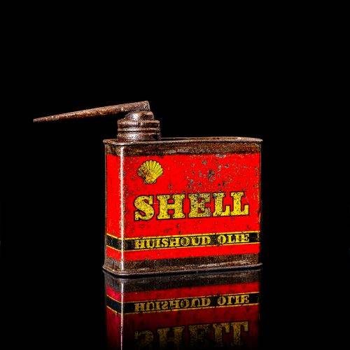Vintage Shell oil cans with red and yellow branding from the 1900-1920 old logo Vintage Shell oil cans from 1900-19255, featuring the old logo. The photo showcases an antique tin red with yellow accents, displaying the historic Shell emblem. Shot in a studio against a solid black background