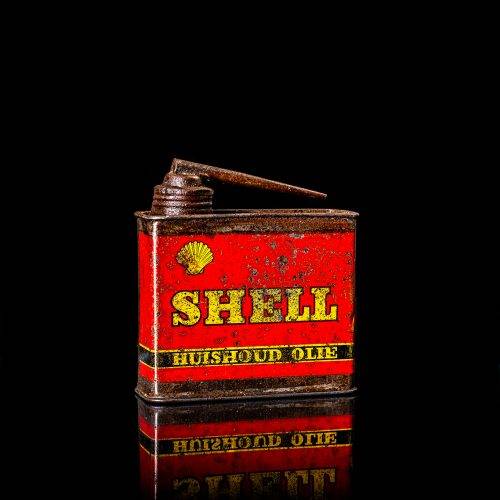 Vintage Shell oil cans with red and yellow branding from the 1900-1920 old logo Vintage Shell oil cans from 1900-19255, featuring the old logo. The photo showcases an antique tin red with yellow accents, displaying the historic Shell emblem. Shot in a studio against a solid black background