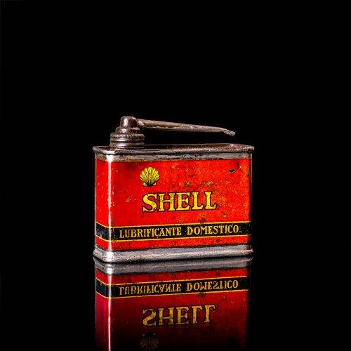 Vintage Shell oil cans with red and yellow branding from the 1900-1920 old logo Vintage Shell oil cans from 1900-19255, featuring the old logo. The photo showcases an antique tin red with yellow accents, displaying the historic Shell emblem. Shot in a studio against a solid black background