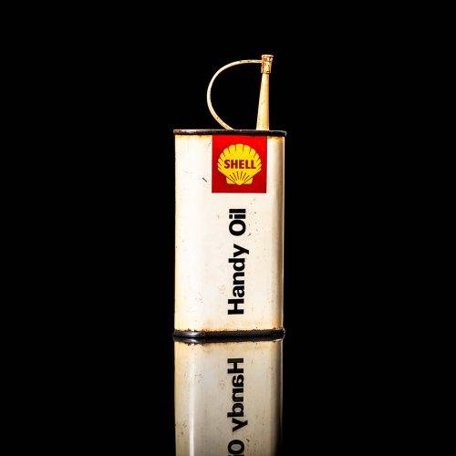 Rare and unique vintage mini Shell oil can Handy oil from 1900–1950 with red and yellow accents, featuring the classic Shell logo. This small antique tin is displayed in a studio setting against a solid black background." Handy oil cans