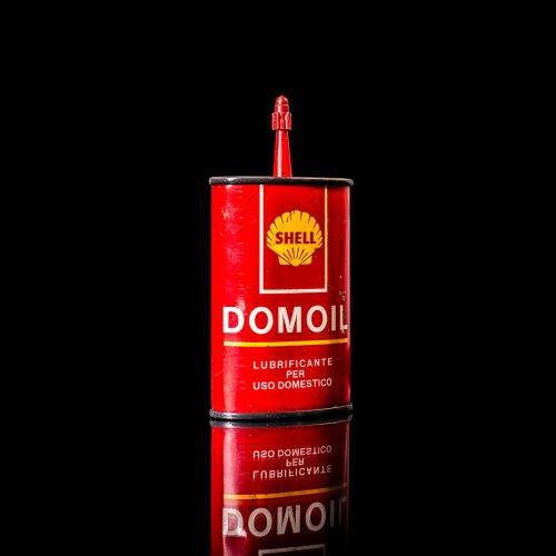 Vintage Shell oil cans with red and yellow branding from the 1900-1920 old logo Vintage Shell oil cans from 1900-19255, featuring the old logo. The photo showcases an antique tin red with yellow accents, displaying the historic Shell emblem. Shot in a studio against a solid black background