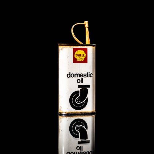 Vintage Shell oil cans with red and yellow branding from the 1900-1920 old logo Vintage Shell oil cans from 1900-19255, featuring the old logo. The photo showcases an antique tin red with yellow accents, displaying the historic Shell emblem. Shot in a studio against a solid black background