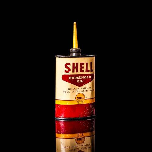 Rare and unique vintage mini Shell oil can Handy oil from 1900–1950 with red and yellow accents, featuring the classic Shell logo. This small antique tin is displayed in a studio setting against a solid black background." Handy oil cans