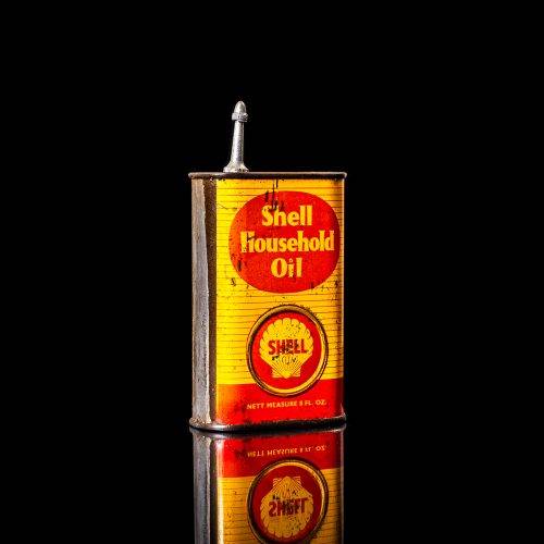Rare and unique vintage mini Shell oil can Handy oil from 1900–1950 with red and yellow accents, featuring the classic Shell logo. This small antique tin is displayed in a studio setting against a solid black background." Handy oil cans