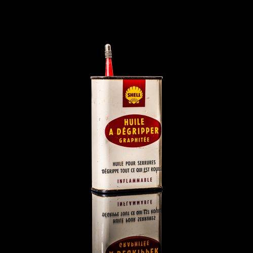 Rare and unique vintage mini Shell oil can Handy oil from 1900–1950 with red and yellow accents, featuring the classic Shell logo. This small antique tin is displayed in a studio setting against a solid black background." Handy oil cans
