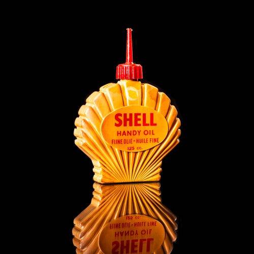 Vintage Shell oil cans with red and yellow branding from the 1900-1920 old logo Vintage Shell oil cans from 1900-19255, featuring the old logo. The photo showcases an antique tin red with yellow accents, displaying the historic Shell emblem. Shot in a studio against a solid black background