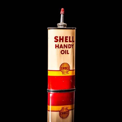 Vintage Shell oil cans with red and yellow branding from the 1900-1920 old logo Vintage Shell oil cans from 1900-19255, featuring the old logo. The photo showcases an antique tin red with yellow accents, displaying the historic Shell emblem. Shot in a studio against a solid black background