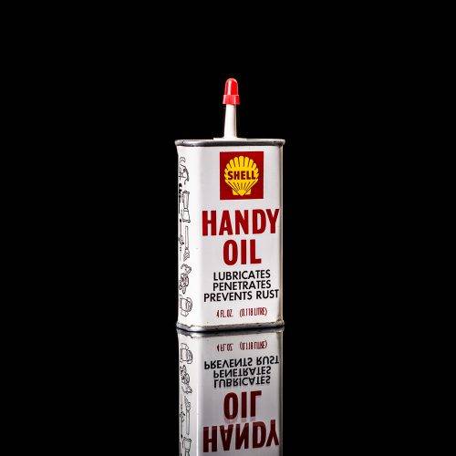 Rare and unique vintage mini Shell oil can Handy oil from 1900–1950 with red and yellow accents, featuring the classic Shell logo. This small antique tin is displayed in a studio setting against a solid black background." Handy oil cans