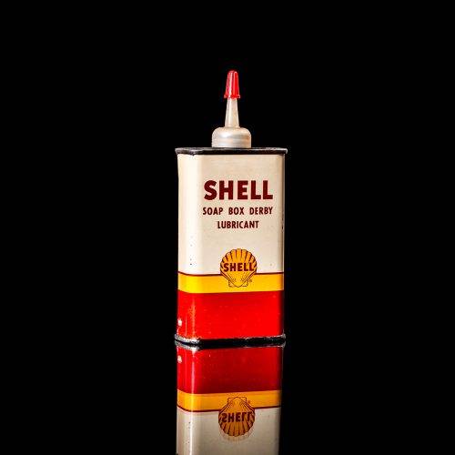 Vintage Shell oil cans with red and yellow branding from the 1900-1920 old logo Vintage Shell oil cans from 1900-19255, featuring the old logo. The photo showcases an antique tin red with yellow accents, displaying the historic Shell emblem. Shot in a studio against a solid black background