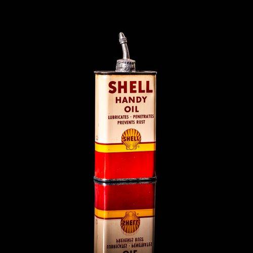 Rare and unique vintage mini Shell oil can Handy oil from 1900–1950 with red and yellow accents, featuring the classic Shell logo. This small antique tin is displayed in a studio setting against a solid black background." Handy oil cans