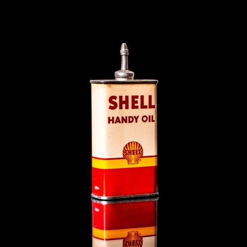 Vintage Shell oil cans with red and yellow branding from the 1900-1920 old logo Vintage Shell oil cans from 1900-19255, featuring the old logo. The photo showcases an antique tin red with yellow accents, displaying the historic Shell emblem. Shot in a studio against a solid black background