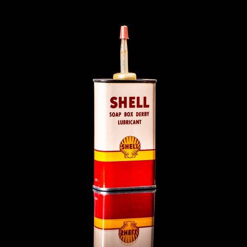 Rare and unique vintage mini Shell oil can Handy oil from 1900–1950 with red and yellow accents, featuring the classic Shell logo. This small antique tin is displayed in a studio setting against a solid black background." Handy oil cans