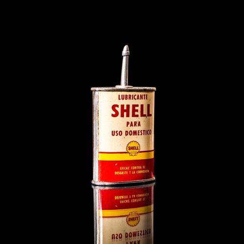 Vintage Shell oil cans with red and yellow branding from the 1900-1920 old logo Vintage Shell oil cans from 1900-19255, featuring the old logo. The photo showcases an antique tin red with yellow accents, displaying the historic Shell emblem. Shot in a studio against a solid black background