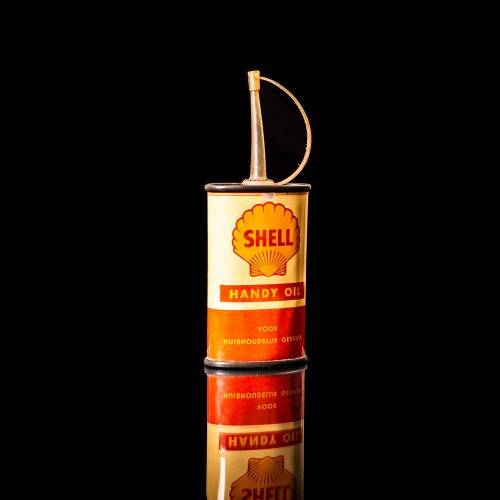 Vintage Shell oil cans with red and yellow branding from the 1900-1920 old logo Vintage Shell oil cans from 1900-19255, featuring the old logo. The photo showcases an antique tin red with yellow accents, displaying the historic Shell emblem. Shot in a studio against a solid black background