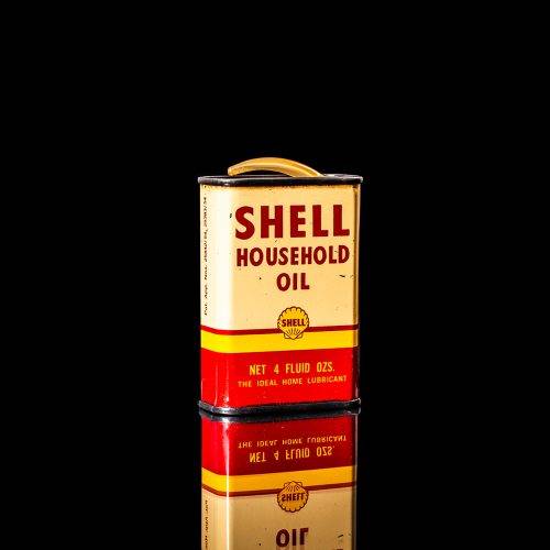 Rare and unique vintage mini Shell oil can Handy oil from 1900–1950 with red and yellow accents, featuring the classic Shell logo. This small antique tin is displayed in a studio setting against a solid black background." Handy oil cans