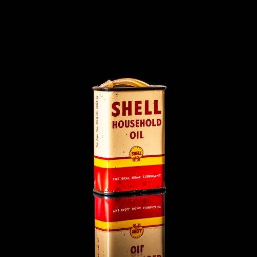 Rare and unique vintage mini Shell oil can Handy oil from 1900–1950 with red and yellow accents, featuring the classic Shell logo. This small antique tin is displayed in a studio setting against a solid black background." Handy oil cans