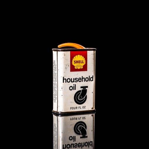 Vintage Shell oil cans with red and yellow branding from the 1900-1920 old logo Vintage Shell oil cans from 1900-19255, featuring the old logo. The photo showcases an antique tin red with yellow accents, displaying the historic Shell emblem. Shot in a studio against a solid black background