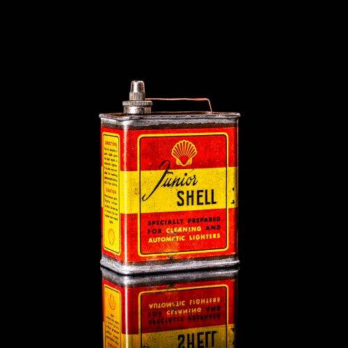 Vintage Shell oil cans with red and yellow branding from the 1900-1920 old logo Vintage Shell oil cans from 1900-19255, featuring the old logo. The photo showcases an antique tin red with yellow accents, displaying the historic Shell emblem. Shot in a studio against a solid black background