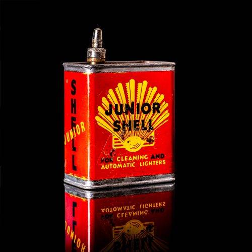 Vintage Shell oil cans with red and yellow branding from the 1900-1920 old logo Vintage Shell oil cans from 1900-19255, featuring the old logo. The photo showcases an antique tin red with yellow accents, displaying the historic Shell emblem. Shot in a studio against a solid black background