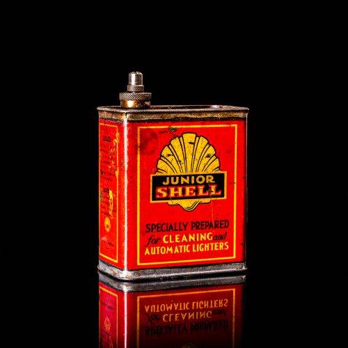 Vintage Shell oil cans with red and yellow branding from the 1900-1920 old logo Vintage Shell oil cans from 1900-19255, featuring the old logo. The photo showcases an antique tin red with yellow accents, displaying the historic Shell emblem. Shot in a studio against a solid black background