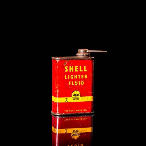 Vintage Shell oil cans with red and yellow branding from the 1900-1920 old logo Vintage Shell oil cans from 1900-19255, featuring the old logo. The photo showcases an antique tin red with yellow accents, displaying the historic Shell emblem. Shot in a studio against a solid black background
