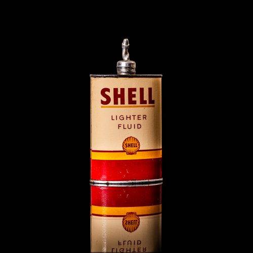 Vintage Shell oil cans with red and yellow branding from the 1900-1920 old logo Vintage Shell oil cans from 1900-19255, featuring the old logo. The photo showcases an antique tin red with yellow accents, displaying the historic Shell emblem. Shot in a studio against a solid black background