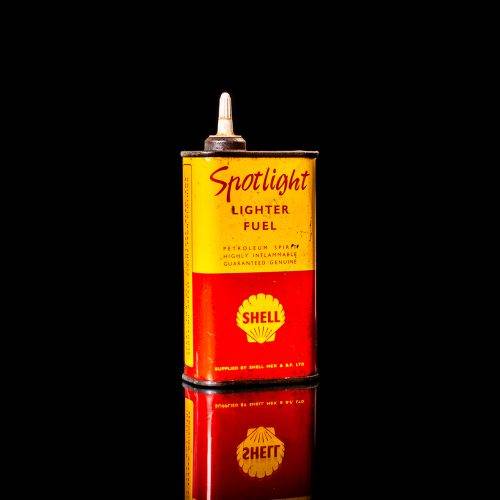 Rare and unique vintage mini Shell oil can from 1900–1950 with red and yellow accents, featuring the classic Shell logo. This small antique tin is displayed in a studio setting against a solid black background. lighter fluid shell cans