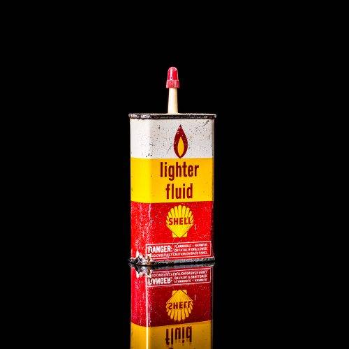 Rare and unique vintage mini Shell oil can from 1900–1950 with red and yellow accents, featuring the classic Shell logo. This small antique tin is displayed in a studio setting against a solid black background." lighter fluid shell cans