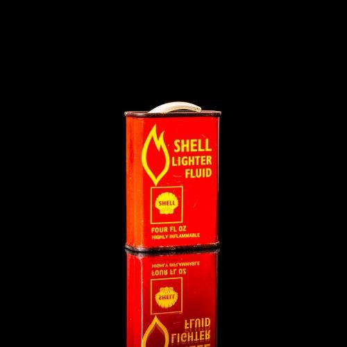 Rare and unique vintage mini Shell oil can from 1900–1950 with red and yellow accents, featuring the classic Shell logo. This small antique tin is displayed in a studio setting against a solid black background." lighter fluid shell cans