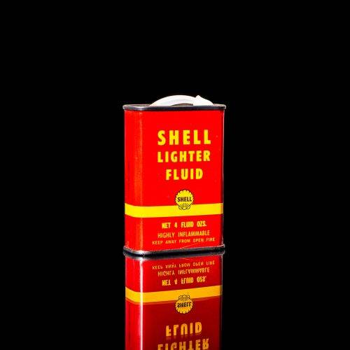 Rare and unique vintage mini Shell oil can from 1900–1950 with red and yellow accents, featuring the classic Shell logo. This small antique tin is displayed in a studio setting against a solid black background." lighter fluid shell cans