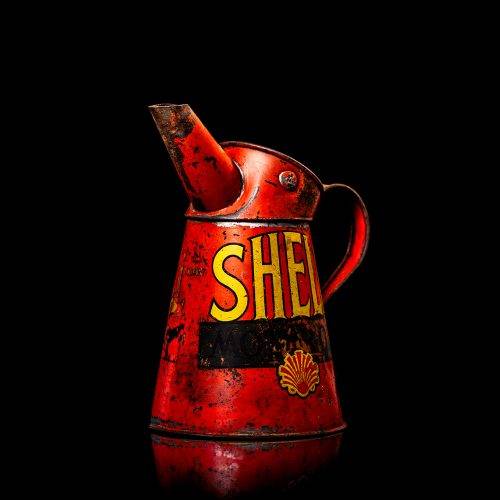 Vintage Shell oil cans with red and yellow branding from the 1900-1920 old logo Vintage Shell oil cans from 1900-19255, featuring the old logo. The photo showcases an antique tin red with yellow accents, displaying the historic Shell emblem. Shot in a studio against a solid black background