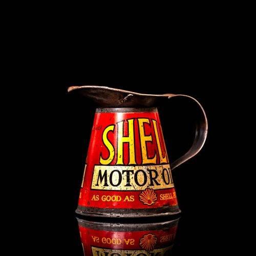 Rare and unique vintage Shell oil pourer from 1900–1950 with red and yellow accents, featuring the classic Shell logo. This antique metal spout can is displayed in a studio setting against a solid black background.