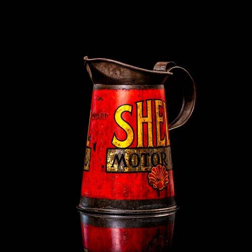 Rare and unique vintage Shell oil pourer from 1900–1950 with red and yellow accents, featuring the classic Shell logo. This antique metal spout can is displayed in a studio setting against a solid black background.
