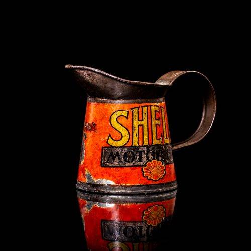 Rare and unique vintage Shell oil pourer from 1900–1950 with red and yellow accents, featuring the classic Shell logo. This antique metal spout can is displayed in a studio setting against a solid black background.