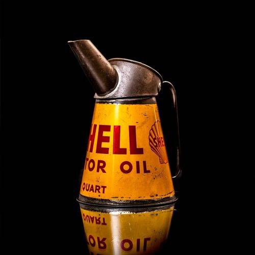Vintage Shell oil cans with red and yellow branding from the 1900-1920 old logo Vintage Shell oil cans from 1900-19255, featuring the old logo. The photo showcases an antique tin red with yellow accents, displaying the historic Shell emblem. Shot in a studio against a solid black background