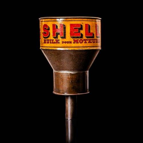 Rare and unique vintage Shell oil pourer from 1900–1950 with red and yellow accents, featuring the classic Shell logo. This antique metal spout can is displayed in a studio setting against a solid black background.