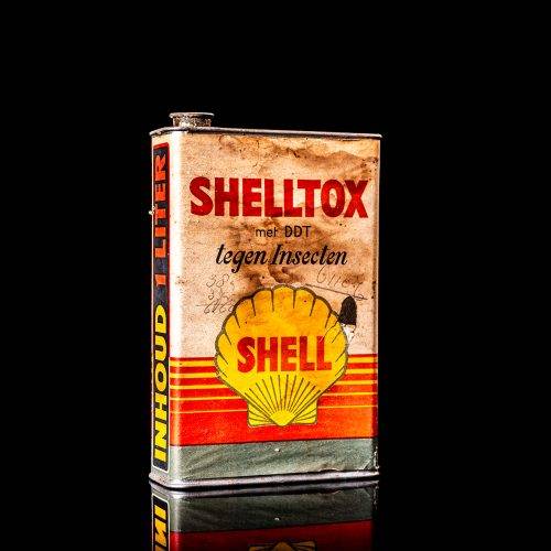 Rare and unique vintage Shell DDT can from 1900–1950, featuring bold red and yellow Shelltox branding and the classic Shell logo. This antique pesticide tin is displayed in a studio setting against a solid black background.