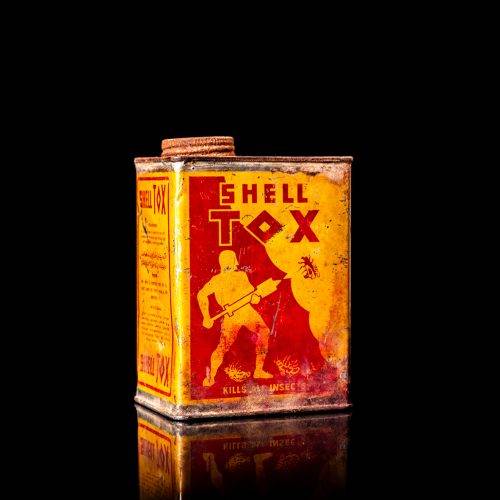 Rare and unique vintage Shell DDT can from 1900–1950, featuring bold red and yellow Shelltox branding and the classic Shell logo. This antique pesticide tin is displayed in a studio setting against a solid black background.