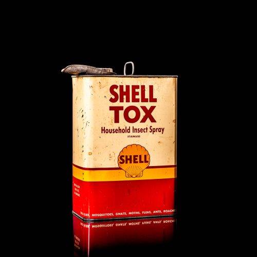 Rare and unique vintage Shell DDT can from 1900–1950, featuring bold red and yellow Shelltox branding and the classic Shell logo. This antique pesticide tin is displayed in a studio setting against a solid black background.