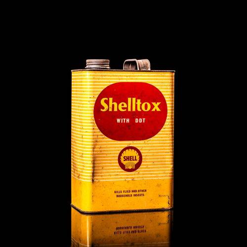 Rare and unique vintage Shell DDT can from 1900–1950, featuring bold red and yellow Shelltox branding and the classic Shell logo. This antique pesticide tin is displayed in a studio setting against a solid black background.