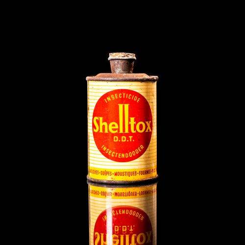 Rare and unique vintage Shell DDT can from 1900–1950, featuring bold red and yellow Shelltox branding and the classic Shell logo. This antique pesticide tin is displayed in a studio setting against a solid black background.