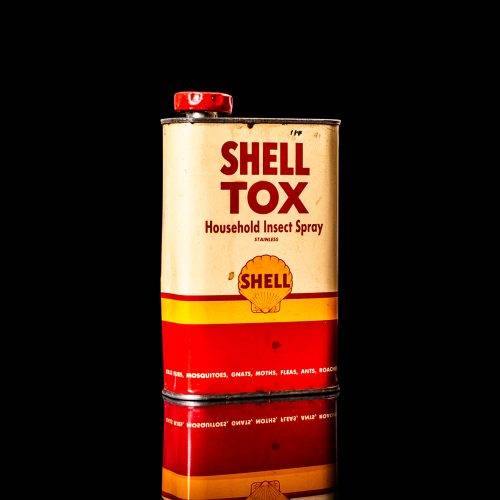 Rare and unique vintage Shell DDT can from 1900–1950, featuring bold red and yellow Shelltox branding and the classic Shell logo. This antique pesticide tin is displayed in a studio setting against a solid black background.