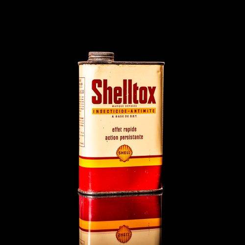 Rare and unique vintage Shell DDT can from 1900–1950, featuring bold red and yellow Shelltox branding and the classic Shell logo. This antique pesticide tin is displayed in a studio setting against a solid black background.