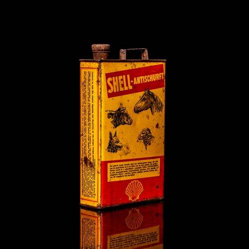 Rare and unique vintage Shell DDT can from 1900–1950, featuring bold red and yellow Shelltox branding and the classic Shell logo. This antique pesticide tin is displayed in a studio setting against a solid black background.